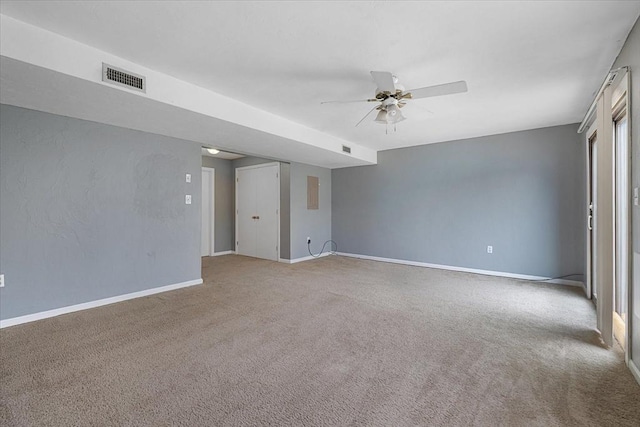carpeted spare room featuring a ceiling fan and baseboards