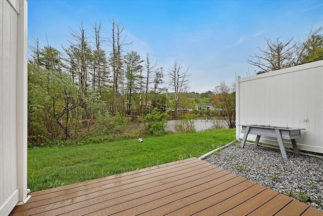 deck with a water view and a lawn