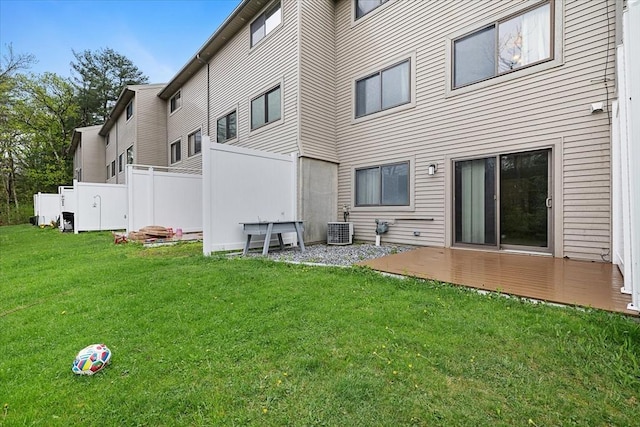 rear view of house with a lawn and central AC unit