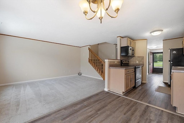 kitchen with appliances with stainless steel finishes, baseboards, a chandelier, dark wood finished floors, and decorative backsplash