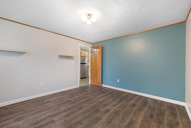 spare room featuring crown molding, dark wood finished floors, baseboards, and a textured ceiling