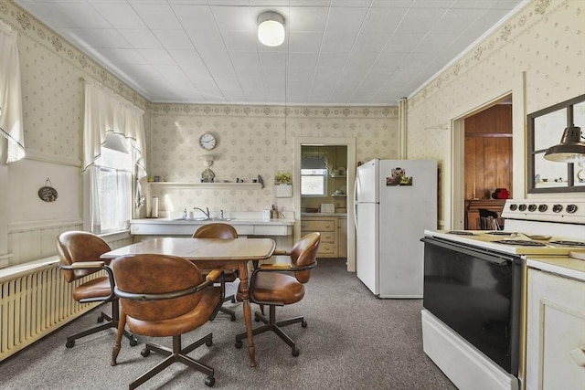 dining space featuring wallpapered walls, radiator heating unit, a healthy amount of sunlight, and carpet floors