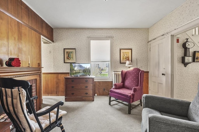 sitting room with wainscoting, radiator heating unit, wallpapered walls, wood walls, and carpet floors