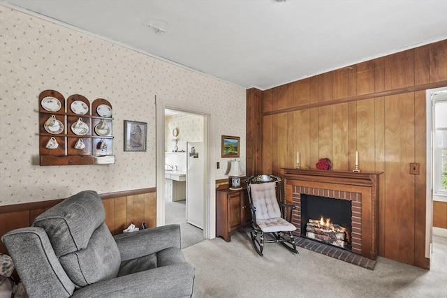 living area with wallpapered walls, a brick fireplace, carpet flooring, and wood walls