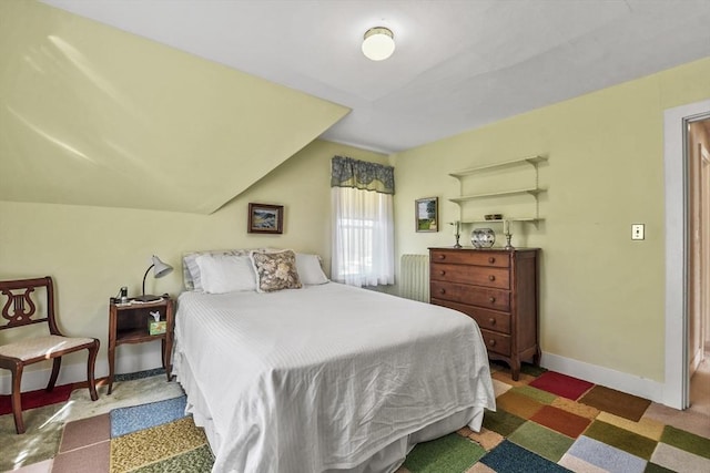 bedroom featuring vaulted ceiling and baseboards