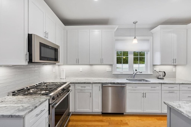 7 Garvey Rd Unit 7, Woburn, MA 01801 - kitchen with appliances with stainless steel finishes, white cabinetry, backsplash, and decorative light fixtures