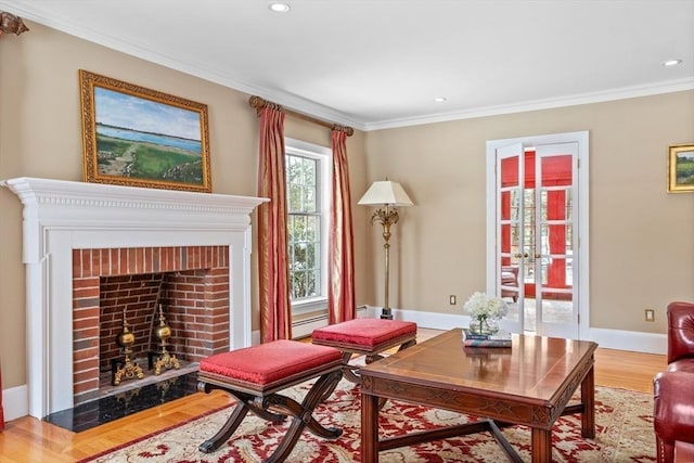 sitting room featuring crown molding, a fireplace, and light wood-type flooring