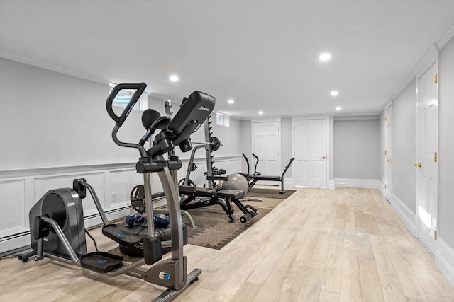 exercise area featuring crown molding and light hardwood / wood-style flooring