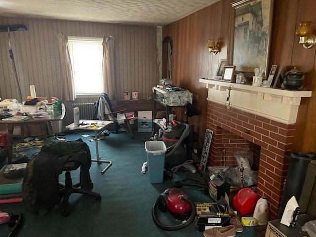 miscellaneous room featuring a fireplace, carpet, and a textured ceiling