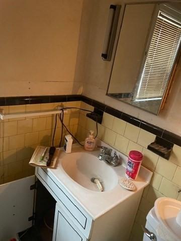 bathroom with vanity and tile walls