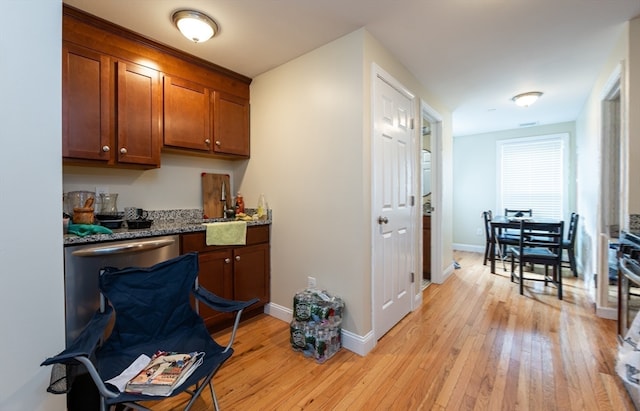 kitchen featuring light hardwood / wood-style flooring and dark stone countertops