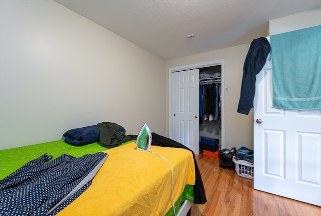 bedroom with wood-type flooring and a closet