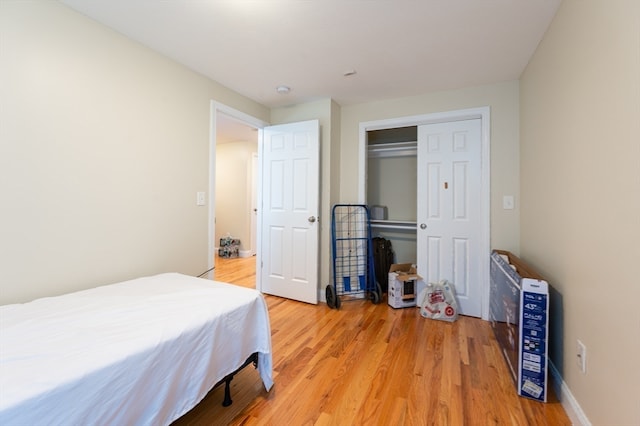 bedroom with light hardwood / wood-style flooring and a closet