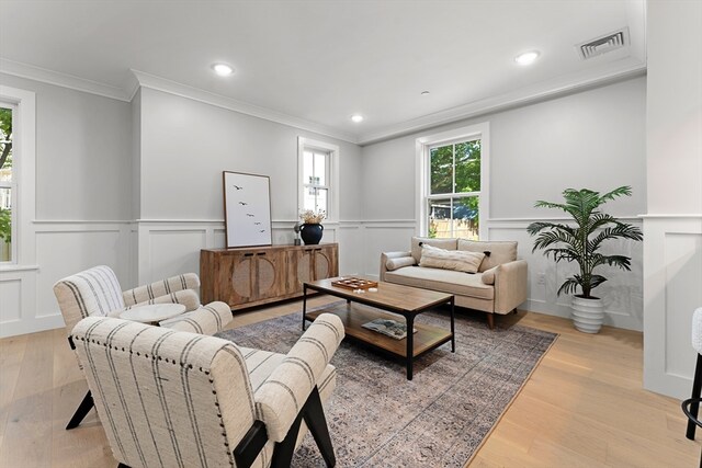 living room with crown molding and light hardwood / wood-style flooring