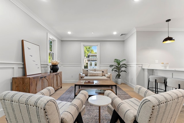 living room featuring crown molding and light hardwood / wood-style flooring