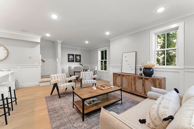 living room featuring crown molding and light hardwood / wood-style floors