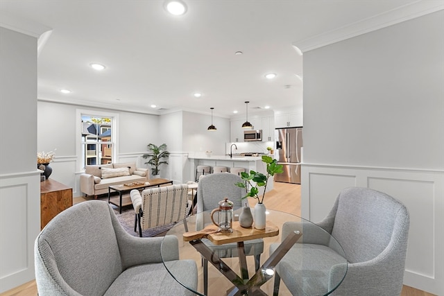 interior space featuring light hardwood / wood-style flooring, crown molding, and sink