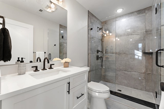 bathroom featuring a shower with shower door, vanity, and toilet