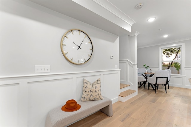 hall featuring light hardwood / wood-style flooring and ornamental molding