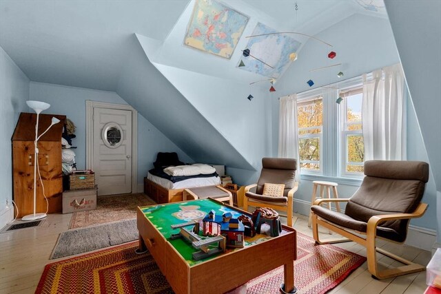 interior space featuring baseboards, wood finished floors, and lofted ceiling