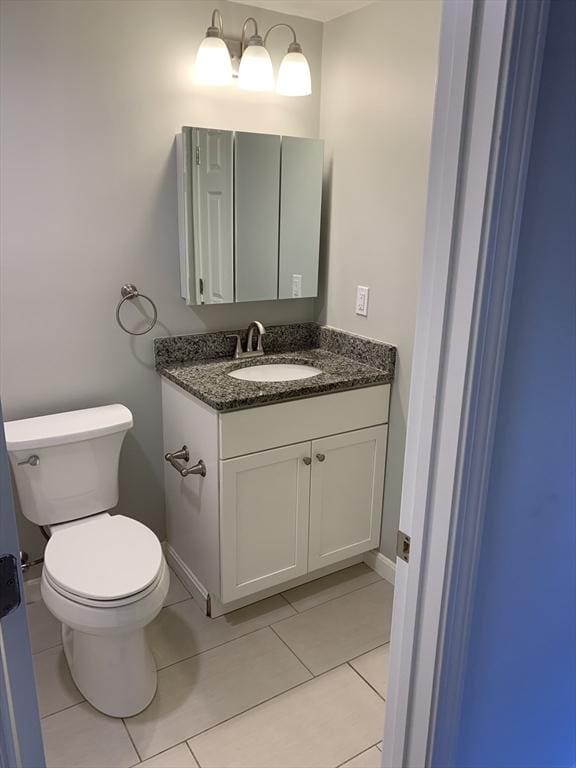 bathroom featuring tile patterned flooring, vanity, and toilet