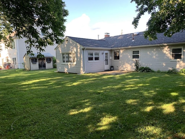 back of property with a patio area, a yard, and a shed