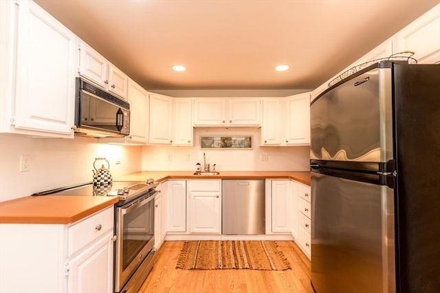 15 Hampton Ct Unit 15, Mashpee, MA 02649 - kitchen featuring appliances with stainless steel finishes, light wood finished floors, recessed lighting, white cabinets, and light countertops