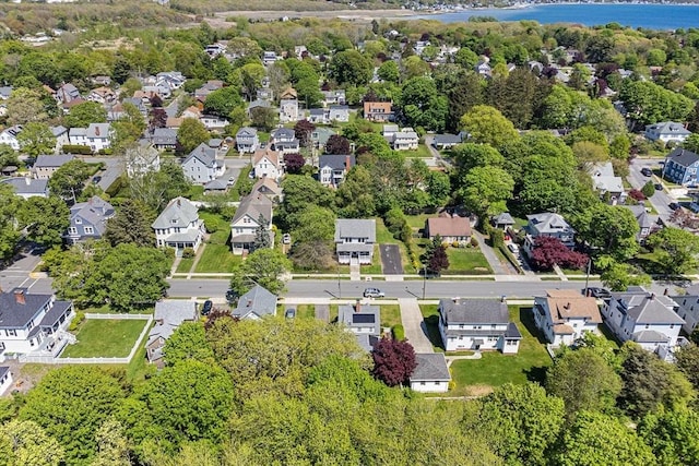 aerial view of property and surrounding area with a large body of water and nearby suburban area