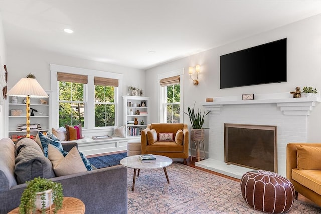 living area featuring a fireplace, recessed lighting, and wood finished floors