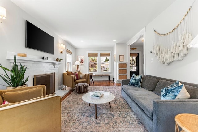 living room featuring a fireplace, wood finished floors, and recessed lighting