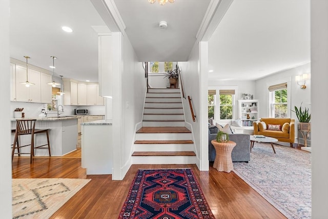 staircase with hardwood / wood-style floors, recessed lighting, and baseboards