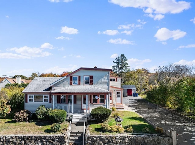 view of front of property with an outbuilding and a front lawn