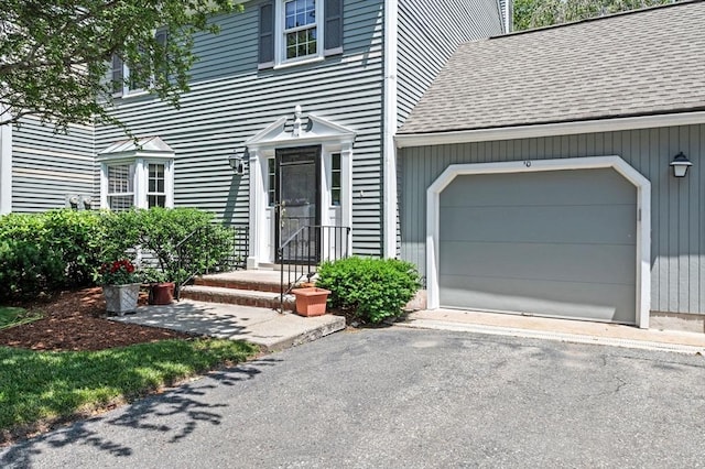 10 Freedom Holw Unit 10, Salem, MA 01970 - view of exterior entry featuring a shingled roof, a garage, and driveway