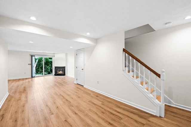 10 Freedom Holw Unit 10, Salem, MA 01970 - unfurnished living room with light wood-type flooring, a glass covered fireplace, stairway, and recessed lighting