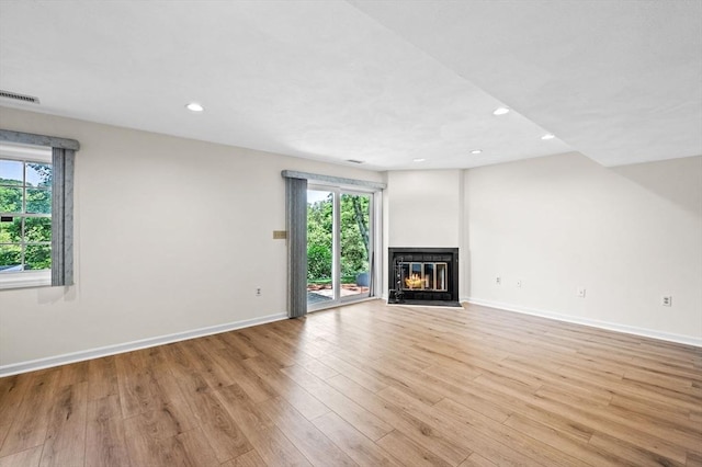 10 Freedom Holw Unit 10, Salem, MA 01970 - unfurnished living room with healthy amount of natural light, a glass covered fireplace, light wood-style floors, and recessed lighting