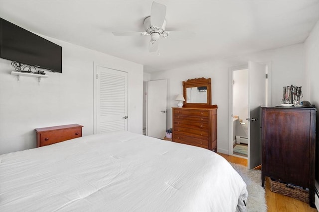 bedroom featuring a baseboard radiator, connected bathroom, ceiling fan, and wood finished floors