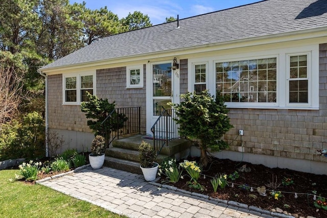 entrance to property with roof with shingles