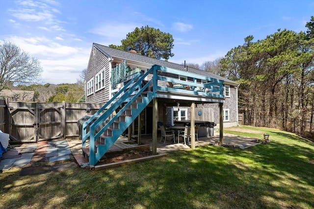 back of property with a deck, a gate, fence, a yard, and a patio