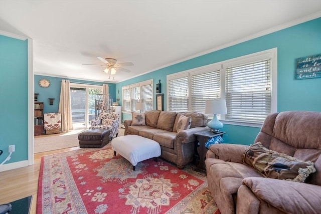 living room with a ceiling fan, baseboards, ornamental molding, and wood finished floors