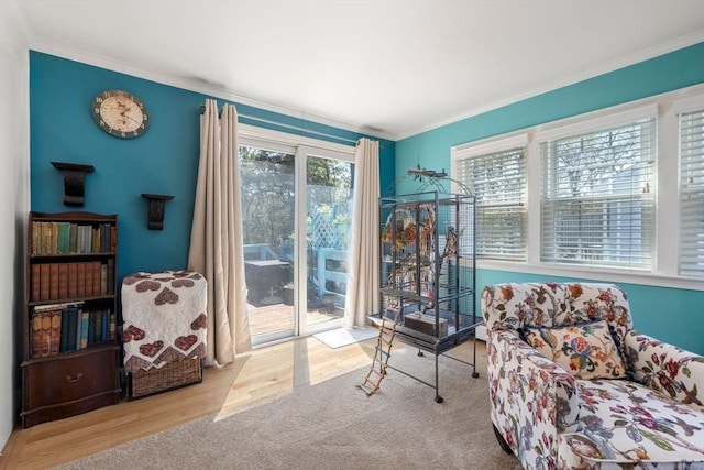 sitting room with ornamental molding and wood finished floors
