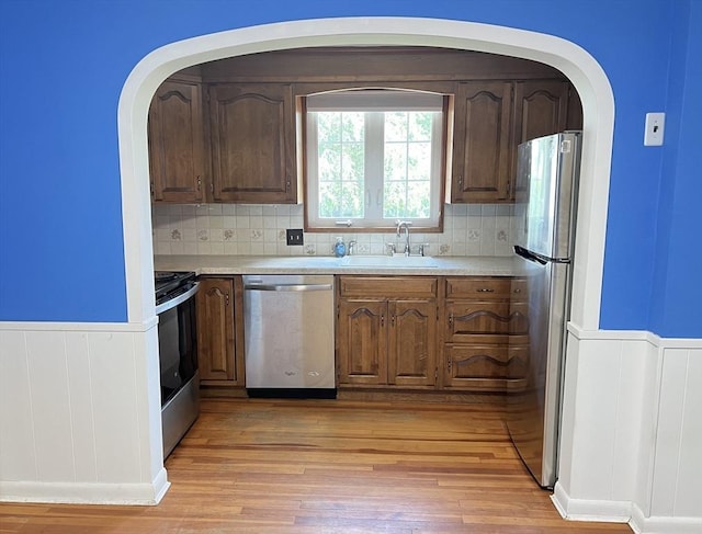 65 Franklin Rd, Longmeadow, MA 01106 - kitchen with stainless steel appliances, a wainscoted wall, light wood-style floors, light countertops, and tasteful backsplash