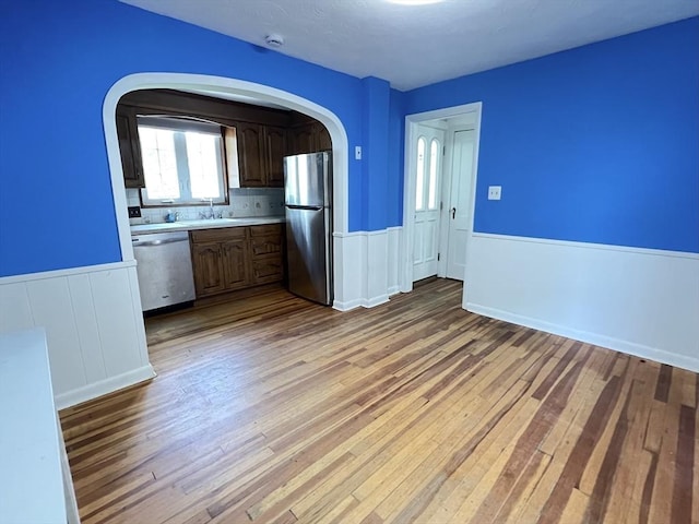65 Franklin Rd, Longmeadow, MA 01106 - kitchen with appliances with stainless steel finishes, a wainscoted wall, light countertops, wood-type flooring, and arched walkways