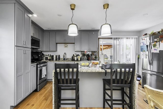 17 Barnard Rd, Lawrence, MA 01843 - kitchen featuring appliances with stainless steel finishes, gray cabinetry, light stone countertops, and light wood finished floors
