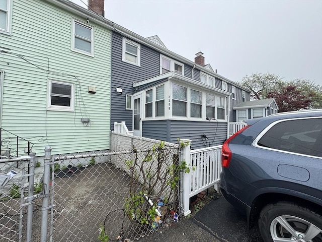 view of home's exterior featuring a chimney and fence
