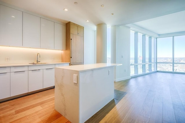 188 Brookline Ave Unit 23C, Boston, MA 02215 - kitchen with light wood-style floors, a wall of windows, light countertops, a kitchen island, and modern cabinets