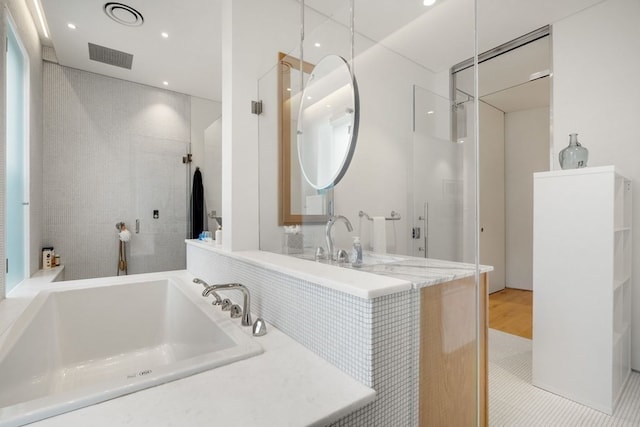 bathroom featuring wood-type flooring, shower with separate bathtub, and sink