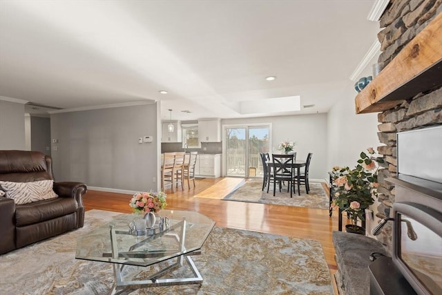 living room with ornamental molding, light hardwood / wood-style floors, and a skylight