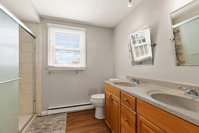 bathroom featuring vanity, wood-type flooring, a baseboard radiator, toilet, and walk in shower