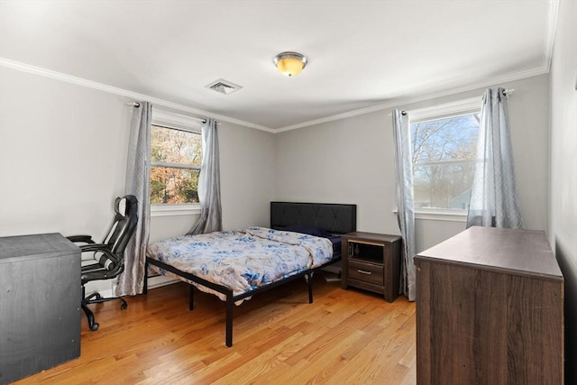 bedroom with crown molding and light hardwood / wood-style flooring