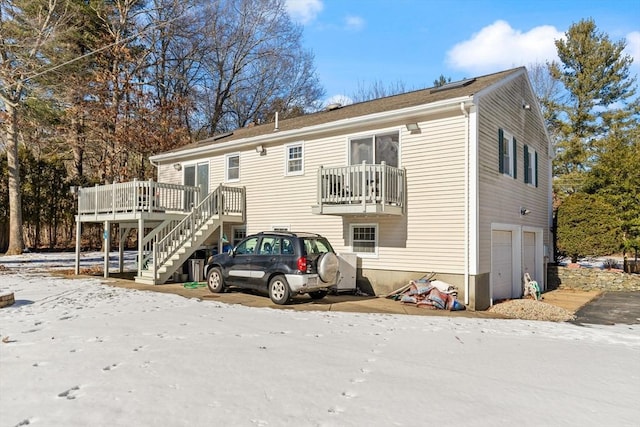 back of property with a garage and a wooden deck